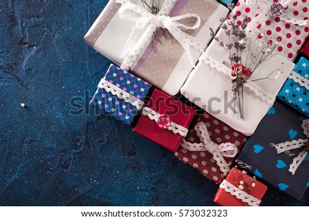 Presents for any holiday concept. Gift boxes frame, top view with copy space on darkblue table background. Border of packages for christmas, valentine day or birthday