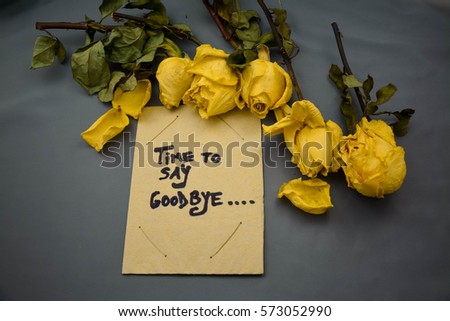 Old paper with time to say goodbye text on it and dried roses