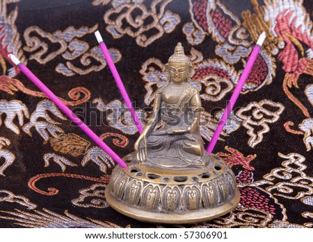 Buddha idol with incense sticks Royalty-Free Stock Photo #57306901