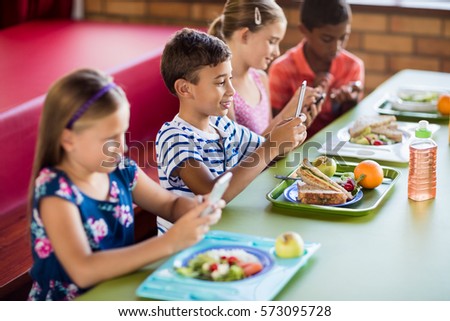 Children using technology during lunch at school