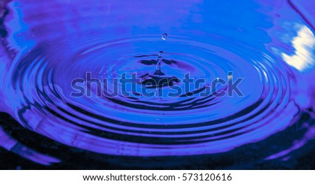 Water drop macro photograph photo image picture. Ripples in water. Purple, blue white. reflection splashing rebound