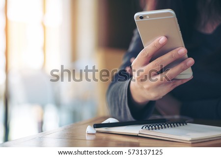 A girl using smart phone and sitting in modern cafe