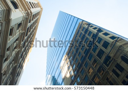 Conceptual image of textured facade of modern design skyscraper office buildings in city business centre, mirror reflection in futuristic window surface upward view and copy space.