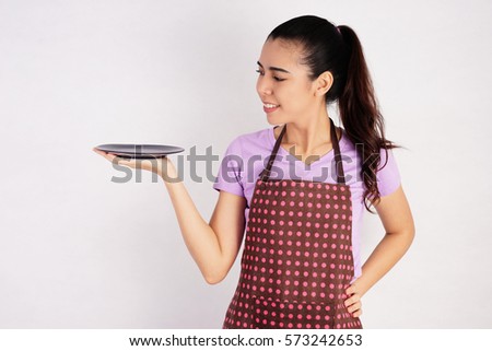Smiling Beautiful Woman holding an Empty Plate on White Background, Cooking Concept