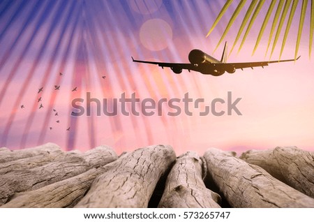 Airplane flying over tropical beach smooth wave and sunset sky abstract background. Copy space of empty old wood table business summer vacation and travel adventure concept.Vintage tone filter color.
