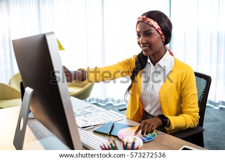 Business woman pointing at her screen in the office