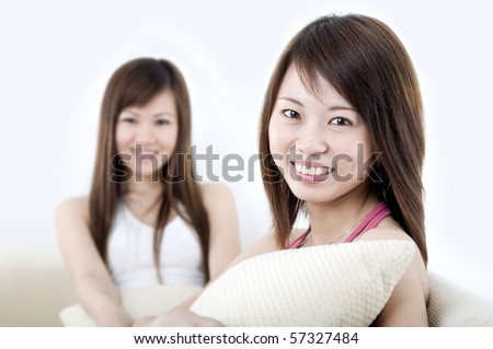 asian girls enjoying while sitting on a sofa