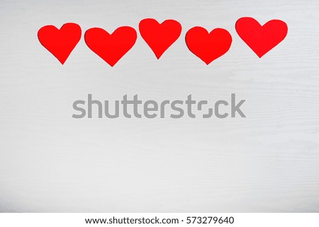Wooden white background with red hearts. The concept of Valentine Day.
