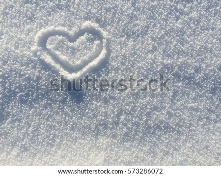 A heart drawn in the winter snow. Royalty-Free Stock Photo #573286072