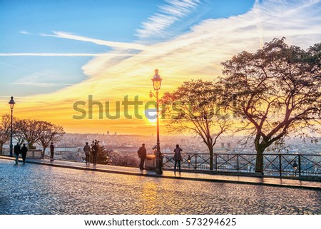 Tourists admire the panoramic view of Paris on the morning sunrise from the Montmartre hill. Royalty-Free Stock Photo #573294625
