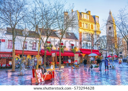 Place du Tertre in Montmartre in Paris. In area lot of souvenirs and handicrafts. In small houses are located cafes, restaurants and art galleries. Royalty-Free Stock Photo #573294628