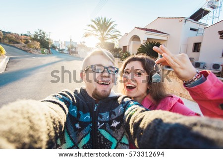 Happy smiling young couple showing a keys of their new house Royalty-Free Stock Photo #573312694