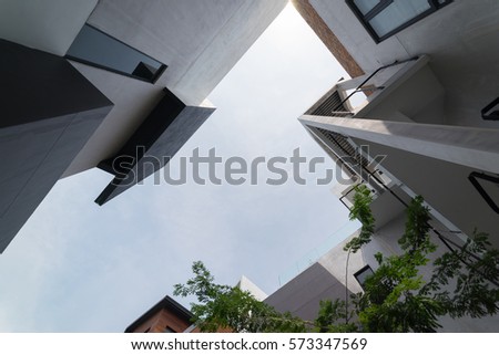 Urban Geometry, looking up to cement building. Modern and abstract architecture design . Royalty-Free Stock Photo #573347569