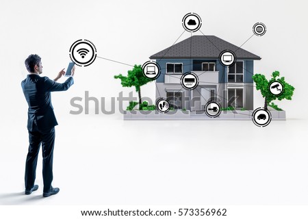 businessman making connection to smart house with tablet PC