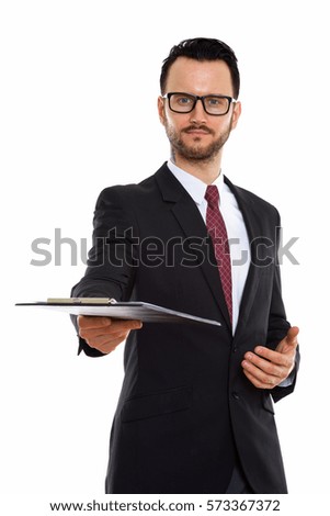 Studio shot of young businessman giving clipboard