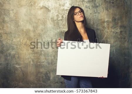 Modern business woman with glasses and jacket posing with a white canvas in the hands of. Horizontal mockup