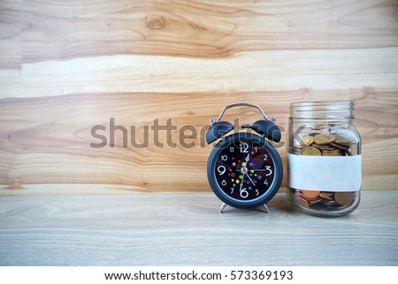 Jar golden coin and alarm clock , copy space