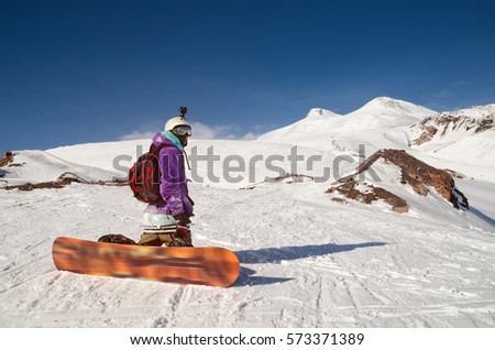 Snowboarder is sitting on mountain slopes of an extinct volcano Elbrus