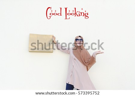Good Looking : The Magic Marketing and Positive Thinking Words seller should use, over the Malaysian lady holding a Gold Paper Bag with authentatic smile and isolated white background.