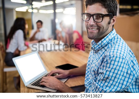 Casual businessman using a laptop during a meeting