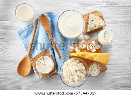 Different types of dairy products on wooden background Royalty-Free Stock Photo #573447319