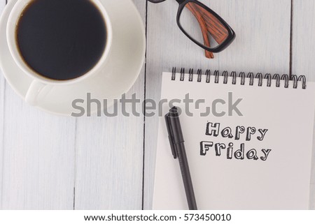 top view of happy friday written on notebook,pen,coffee,glasses on the white desk