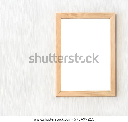 Light wooden frame for picture hanging on white wall. Royalty-Free Stock Photo #573499213