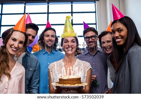 Happy coworkers celebrating a birthday in the office