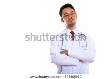 Studio shot of young Asian man doctor wearing eyeglasses with arms crossed