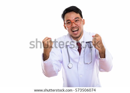 Studio shot of young happy Asian man doctor smiling while looking excited
