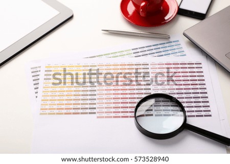 Employee prepress proofing examines through a magnifying glass