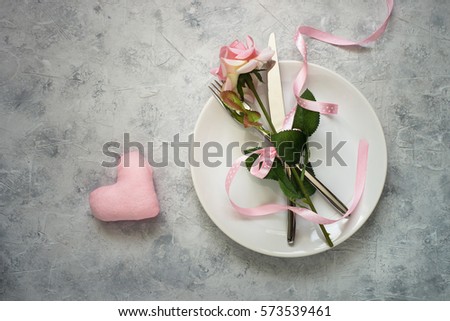 Valentines day table setting. Plate, silverware flower and gift box. Top view copy space.