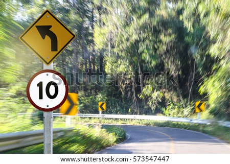 Ten miles per hour speed limit and turn left sign.