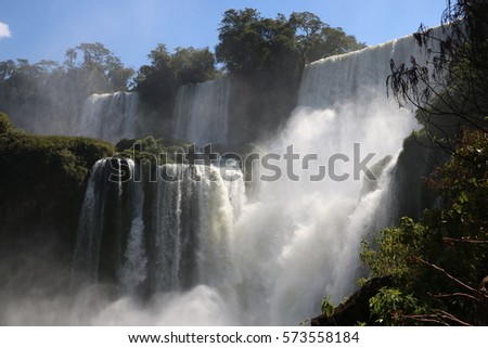 Iguazu falls, the longest waterfalls in the world in a sunny day from Argentinian side, with a rainbow Royalty-Free Stock Photo #573558184