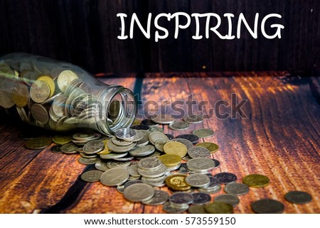 Coins in glass jar for money saving financial and business concept with wording "MARKETING".