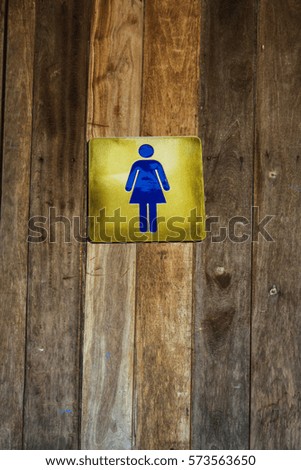 public toilet signs of woman on wooden texture