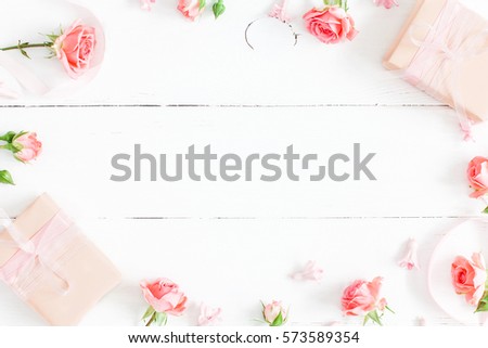 Flowers composition. Gifts and rose flowers on white wooden table. Women Day. Flat lay, top view, copy space