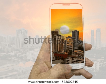 Double exposure of hand hold and touch screen smart phone, mobile and cityscape background.Concept for telecommunication and technology texture.