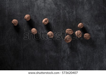 Top view picture of a lot of walnuts over dark background