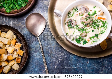 Cheese soup with croutons in white bowl. Blue background. Selective focus. 