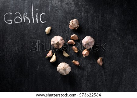 Top view picture of a garlic over dark chalkboard background