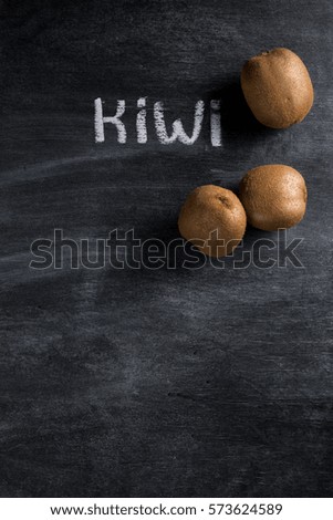 Top view photo of kiwi over dark chalkboard background