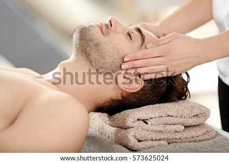 Man having face massage in spa salon