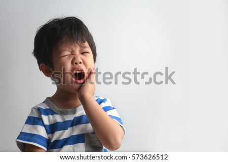 Little Asian boy suffering from toothache - Dental problem.  Royalty-Free Stock Photo #573626512