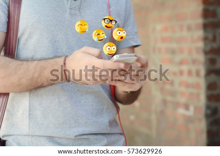 Close-up of man using smartphone sending emojis. Social concept. Royalty-Free Stock Photo #573629926