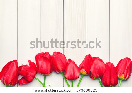 Tulips. Easter. Red tulips on a background of light boards. Spring flowers. Easter 2016. Springtime. Vintage processing. Space for text. Toned image.