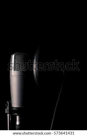 Professional condenser microphone with pop filter in black background