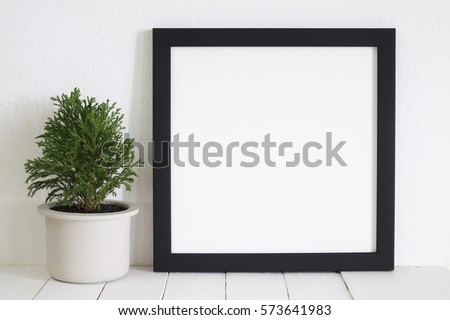 mock up frame with plant pot on wooden table