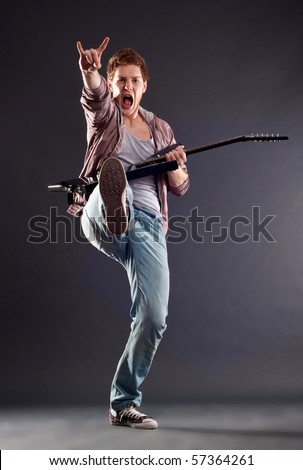 picture of a kicking guitarist playing over dark background