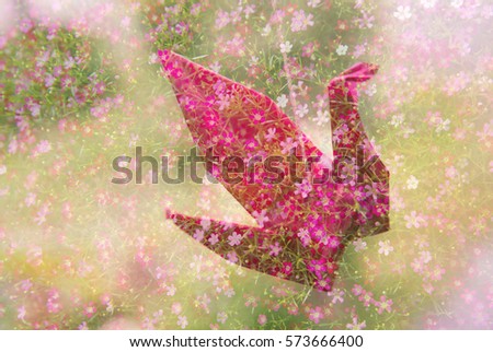 pink paper bird with small flower nature background 
